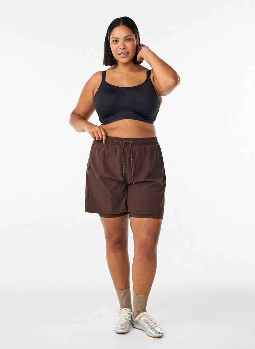 Sports-BH med h&oslash;y st&oslash;tte, b&oslash;yle og polstrede stropper, Svart, Model image number 1